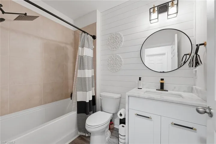 Upgraded guest bath with waterfall quartz countertop, feature wall, upgraded lighting and new accessories.