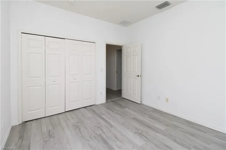 Unfurnished bedroom with light wood-type flooring and a closet