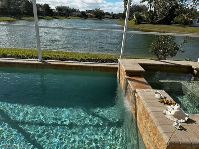 Dock with a water view and a pool with connected hot tub