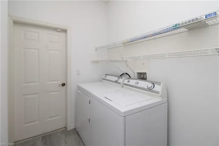 Washroom with independent washer and dryer and light wood-style floors