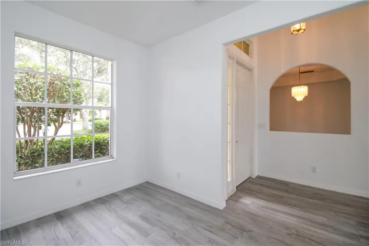 Empty room featuring light wood-style flooring and arched walkways