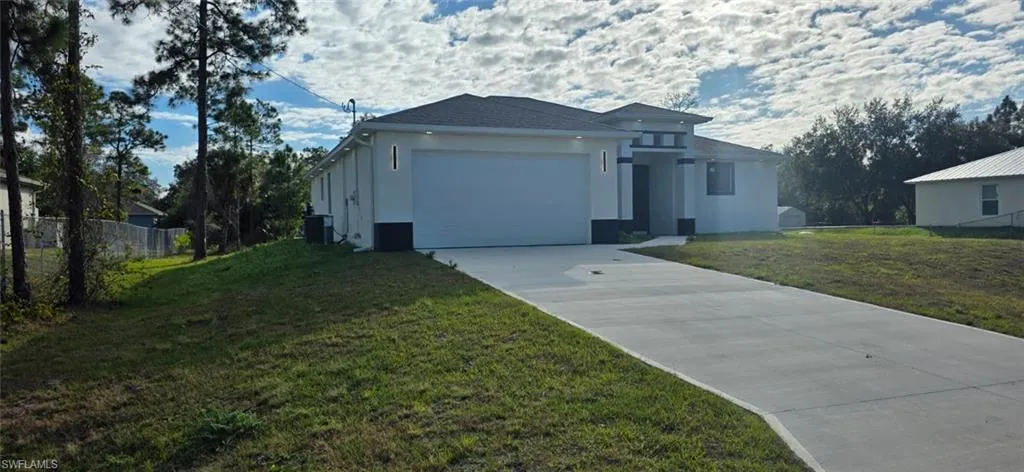 View of front of house with stucco siding, driveway, and an attached garage