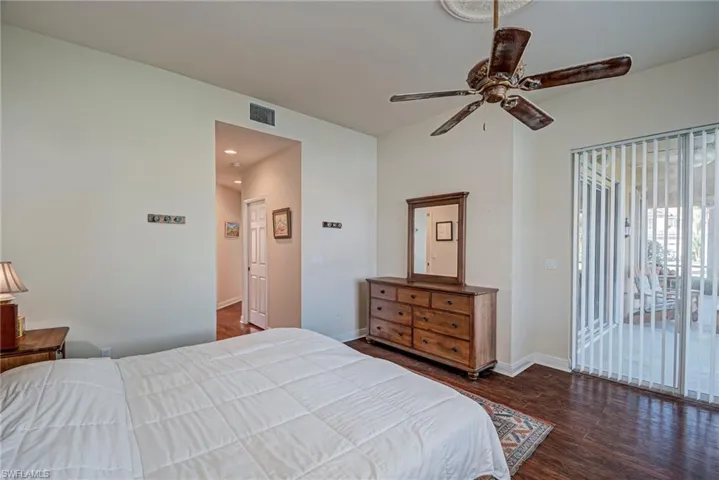 Bedroom featuring access to outside, dark wood-style flooring, and a ceiling fan