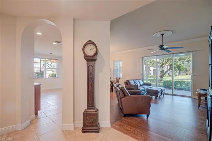 Living area featuring a ceiling fan, arched walkways, and light tile patterned flooring