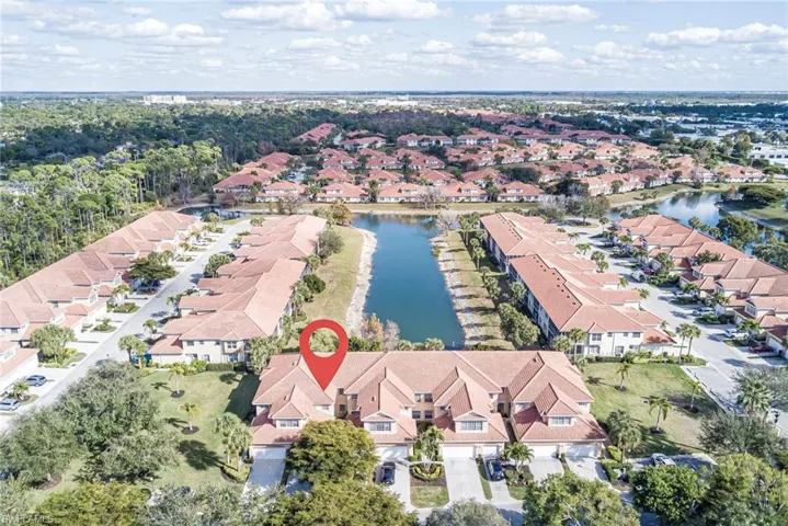 Aerial view of property's location featuring a nearby body of water and nearby suburban area