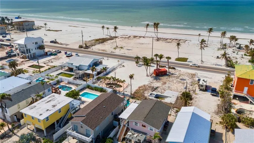VIRTUALLY ENHANCED Birds eye view of property featuring a view of the beach and a water view