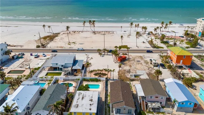 VIRTUALLY ENHANCED Aerial view featuring a view of the beach and a water view