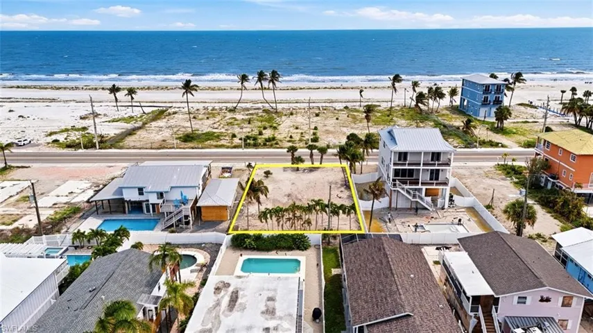 VIRTUALLY ENHANCED - Expansive land parcel with direct beach access, mature palm trees, and ocean frontage