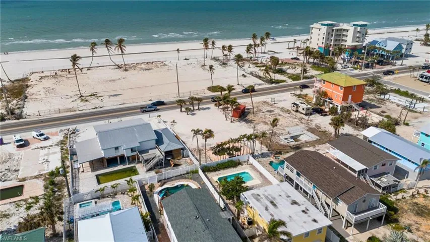 VIRTUALLY ENHANCED Birds eye view of property with a water view and a view of the beach