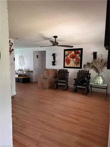 Living area featuring light wood-style floors and a ceiling fan