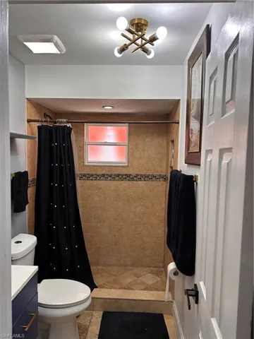 Bathroom featuring vanity, a stall shower, and a chandelier