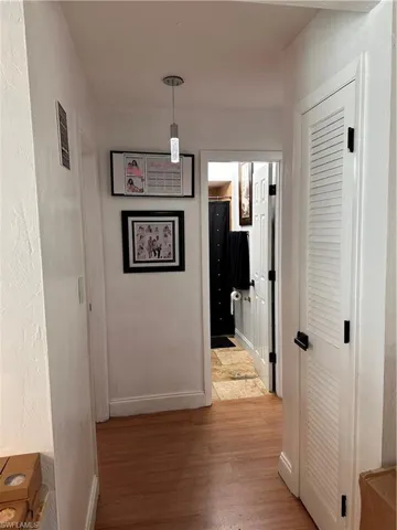 Hall featuring light wood-style flooring and a textured wall
