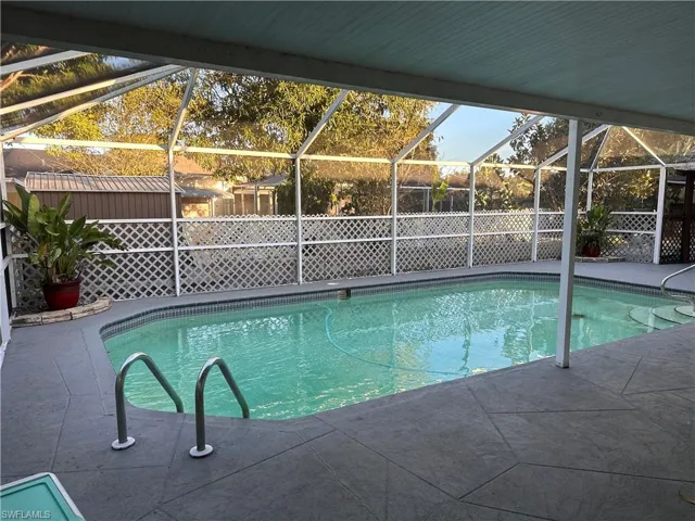 Swimming pool with glass enclosure, a patio, and a sunroom