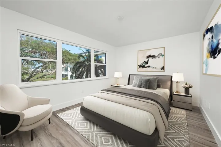 Bedroom with multiple windows and wood-type flooring