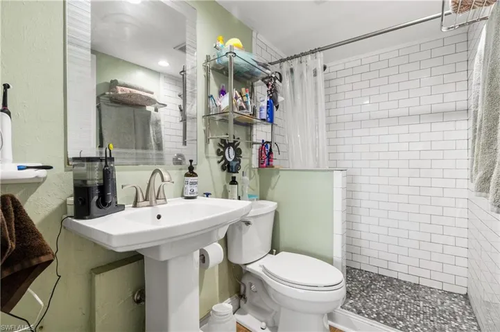 Bathroom with toilet and a shower with shower curtain