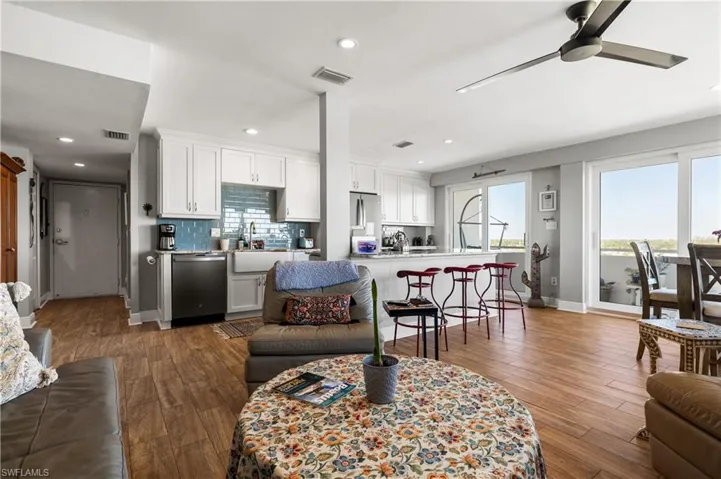 Living room featuring ceiling fan, dark wood-type flooring, and sink