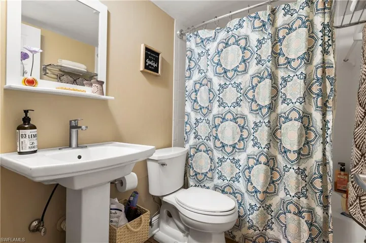 Bathroom featuring shower / bath combination with curtain and toilet