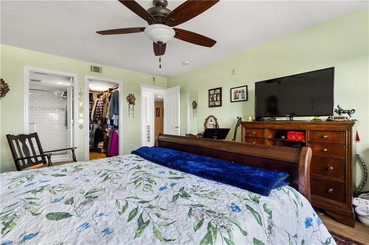 Bedroom featuring hardwood / wood-style floors, ensuite bath, ceiling fan, a spacious closet, and a closet