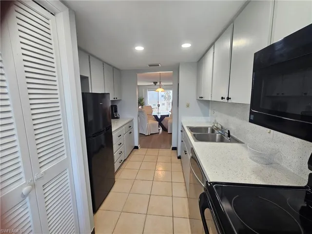 Kitchen with black appliances, light tile patterned floors, recessed lighting, decorative backsplash, and pendant lighting