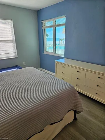 Bedroom with multiple windows and dark wood-type flooring