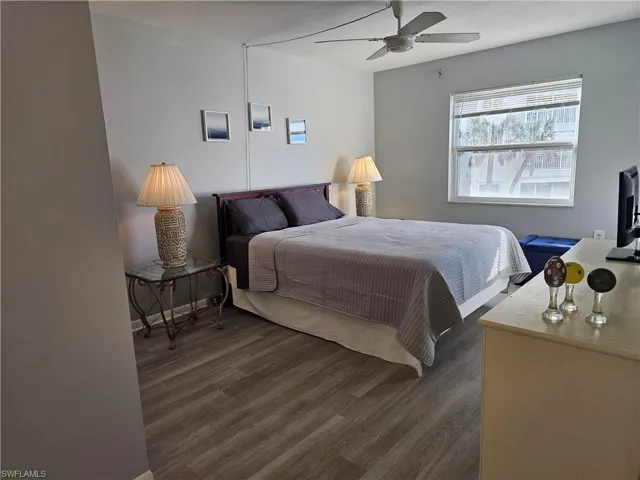 Bedroom with a ceiling fan and dark wood-style flooring