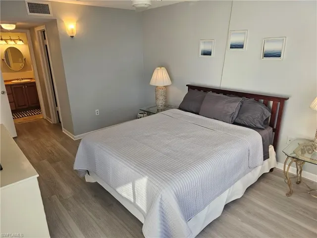 Bedroom featuring wood finished floors and ensuite bathroom