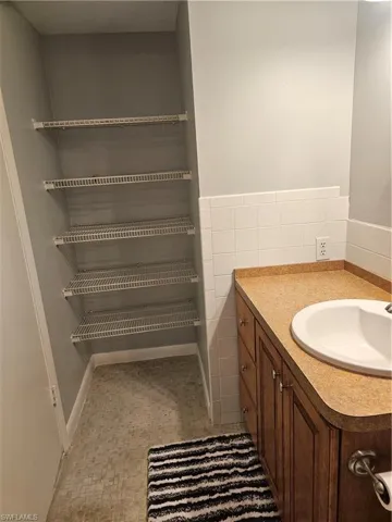 Bathroom featuring vanity, tile walls, and wainscoting