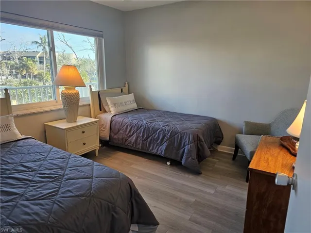 Bedroom with wood finished floors and baseboards