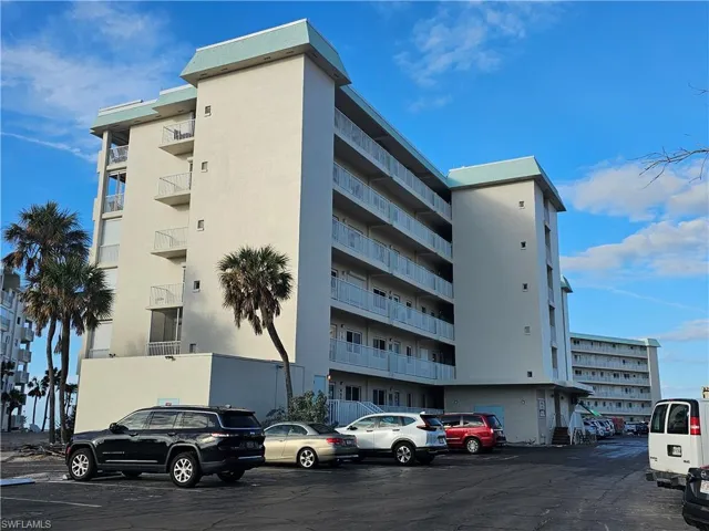 View of apartment building / complex with uncovered parking
