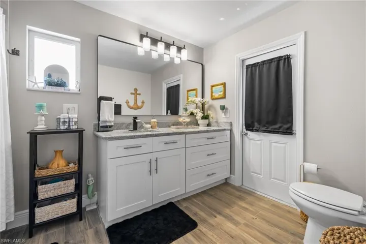 Bathroom with vanity, hardwood / wood-style floors, and toilet