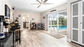Living area featuring ceiling fan, a sunroom, and wood finished floors