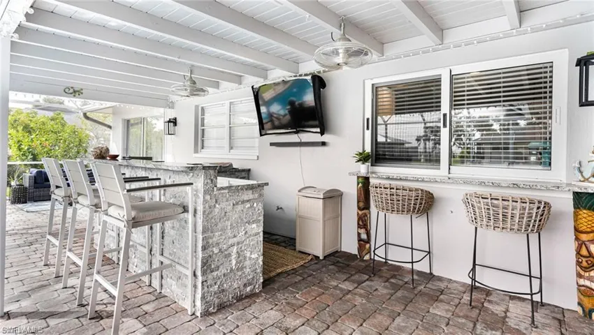 View of patio featuring ceiling fan and an outdoor bar