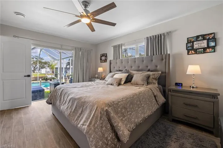Bedroom featuring wood-type flooring, access to exterior, and ceiling fan