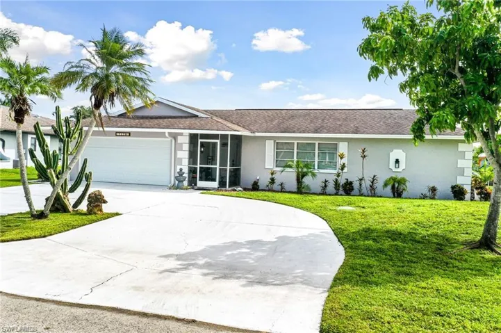 Ranch-style home featuring a garage and a front lawn