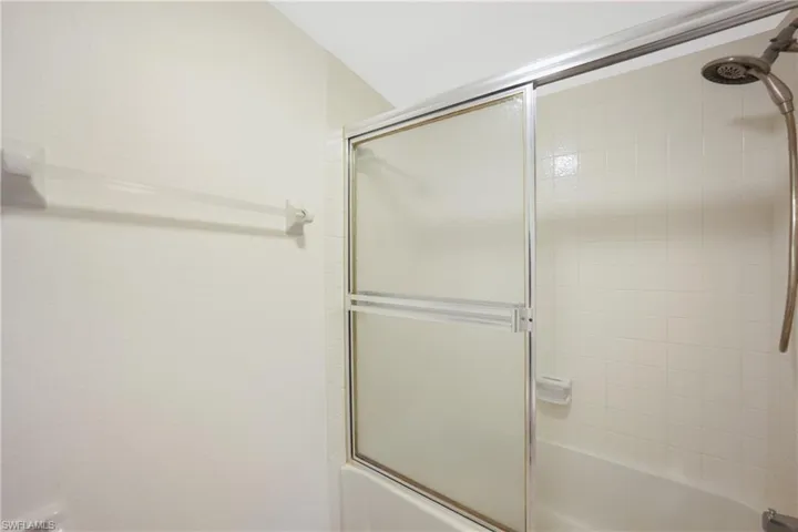 Bathroom featuring combined bath / shower with glass door