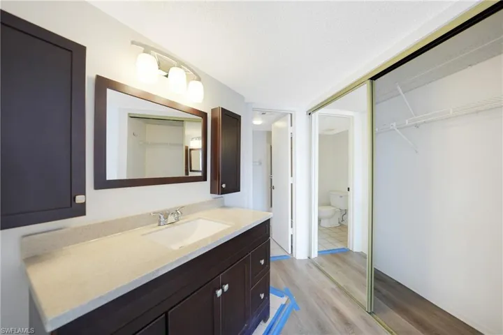 Bathroom featuring hardwood / wood-style floors, vanity, a textured ceiling, and toilet