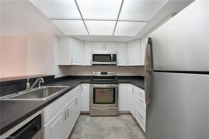 Kitchen with white cabinetry, sink, and stainless steel appliances