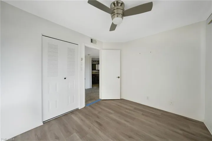 Unfurnished bedroom with hardwood / wood-style floors, ceiling fan, and a closet