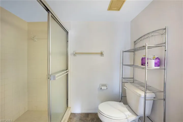 Bathroom featuring toilet and a shower with door