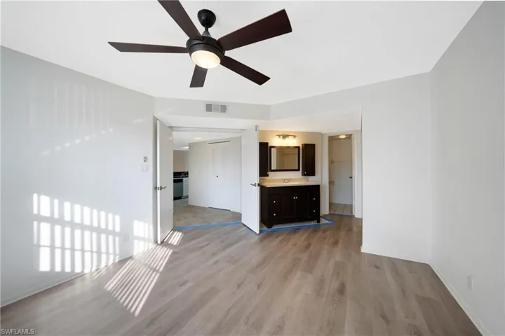 Unfurnished living room featuring ceiling fan, sink, and light wood-type flooring