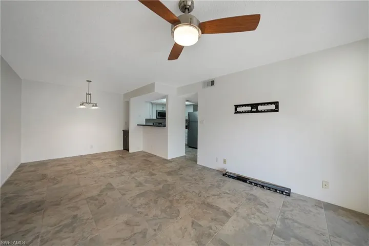 Unfurnished living room featuring a textured ceiling and ceiling fan