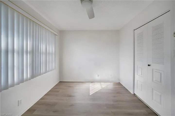 Unfurnished bedroom with a textured ceiling, a closet, light hardwood / wood-style floors, and ceiling fan