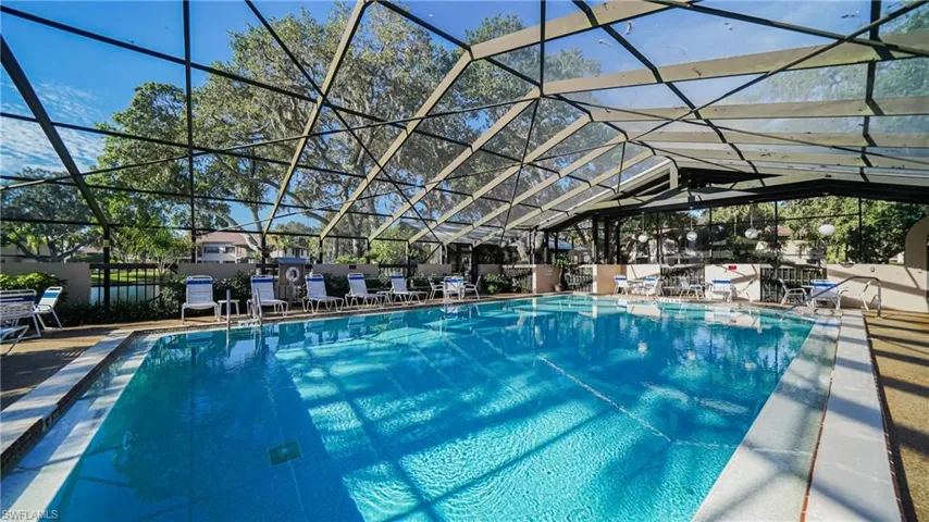 View of swimming pool featuring a patio and glass enclosure