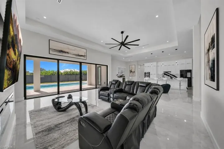 Spacious interior featuring high ceilings, recessed lighting, and expansive sliding glass doors leading to a private swimming pool