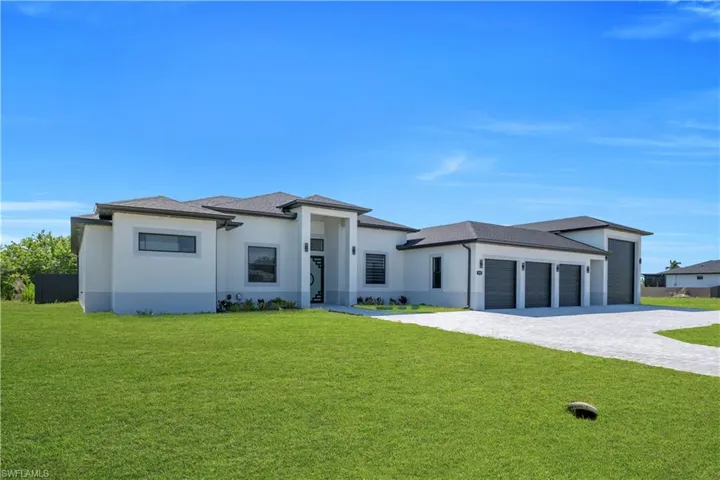 Contemporary residence featuring a paved driveway, three-car garage, separate RV/boat garage, and a modern entrance