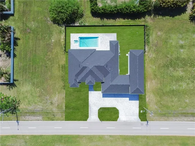 Aerial perspective showcasing a newly constructed home with a dark shingle roof