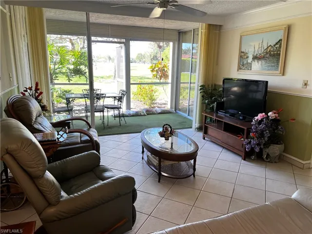 Living room with plenty of natural light, ceiling fan, a textured ceiling, and light tile patterned flooring