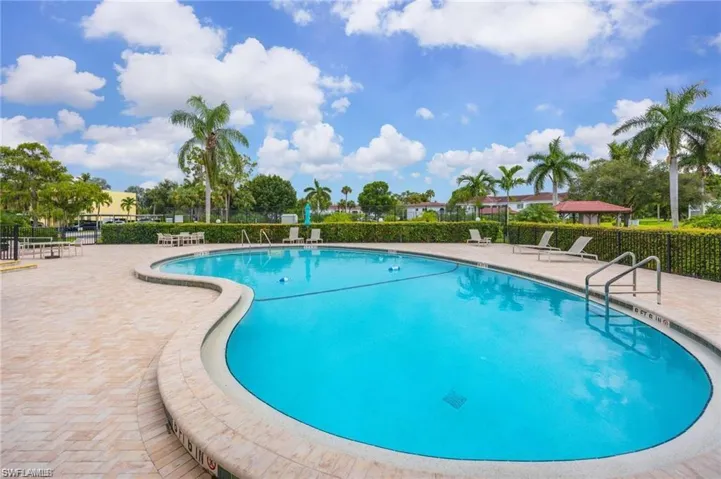 Community pool with a patio and fence