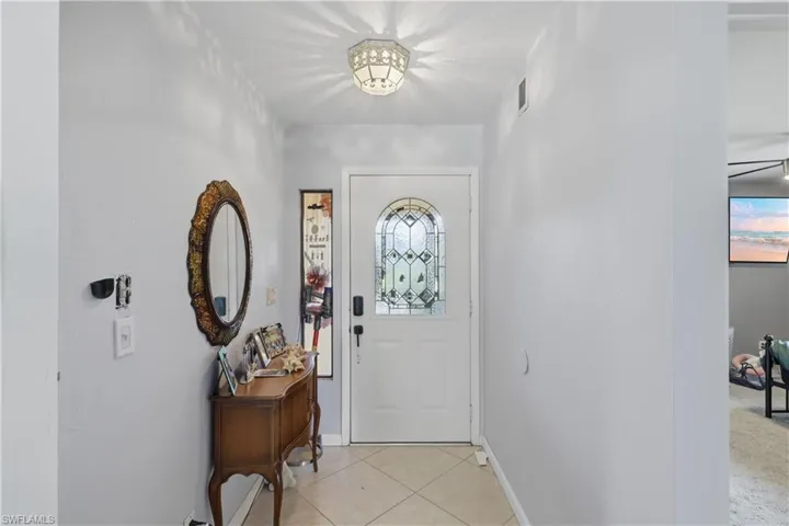 Entryway featuring a decorative transom door, tiled flooring, and a ceiling-mounted light fixture