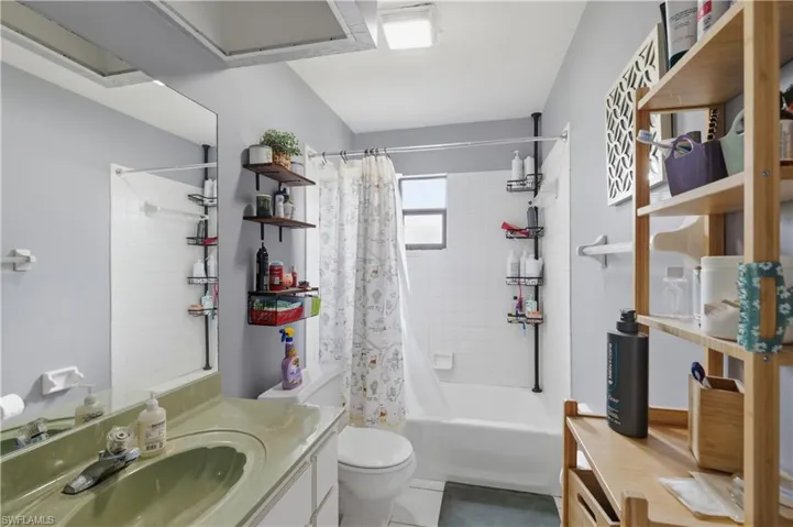 Full-width vanity mirror, built-in bathtub with white subway tile surround, and a single window